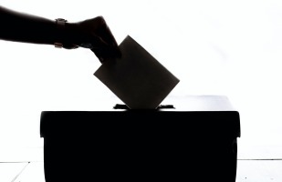 dropping ballot into election box