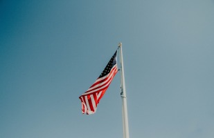 american flag flapping in the wind in a cloudless sky