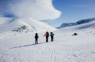 3 hikers making their way through a frozen landscape.