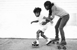 a woman teaching her child how to roller skate.